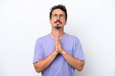 Bıyıklı genç bir adam beyaz arka planda avuçlarını bir arada tutuyor. İnsan bir şey ister.