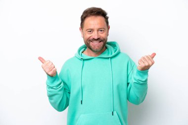 Beyaz arka planda izole edilmiş orta yaşlı beyaz bir adam. Baş parmakları havada ve gülümsüyor.