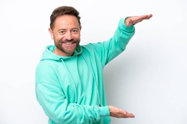 Beyaz arka planda izole edilmiş orta yaşlı beyaz bir adam ilan vermek için kopyalama alanı tutuyor.