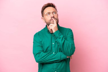 Orta yaşlı, beyaz bir adam pembe arka planda izole edilmiş.