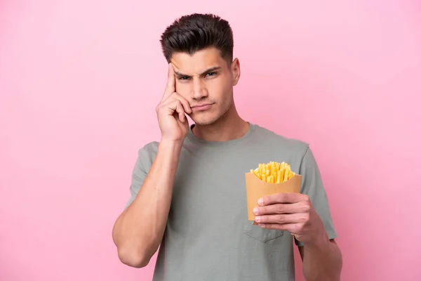 Jovem Caucasiano Segurando Fritas Isoladas Fundo Rosa Pensando Uma Ideia — Fotografia de Stock