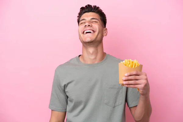 Jonge Kaukasische Man Met Gebakken Chips Geïsoleerd Roze Achtergrond Lachen — Stockfoto