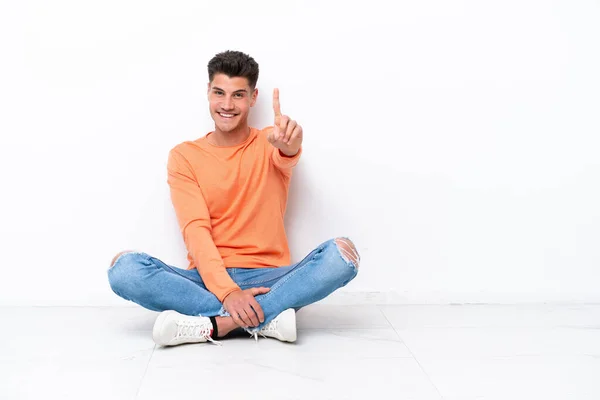 Young Man Sitting Floor Isolated White Background Showing Lifting Finger — Φωτογραφία Αρχείου