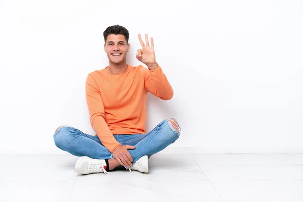 Young Man Sitting Floor Isolated White Background Happy Counting Three — Stock Fotó