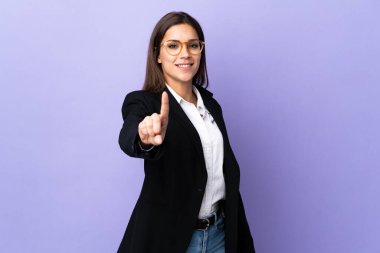 Mor arka planda izole edilmiş bir iş kadını parmağını kaldırıyor.