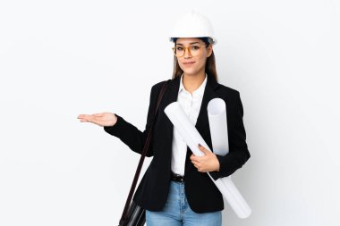 Miğferli, beyaz, genç bir kadın izole edilmiş arka plan üzerinde planları var. Davet etmek için ellerini yana uzatıyor.