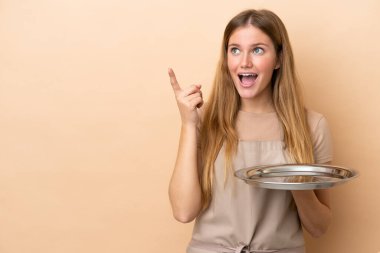 Tepsisi bej arka planda olan genç sarışın garson kız parmağını kaldırarak çözümü bulmaya çalışıyor.