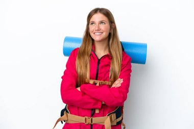 Sırt çantalı genç dağcı kız izole edilmiş beyaz arka planda gülümserken yukarı bakıyor.