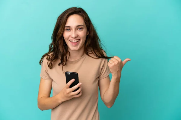 Giovane Donna Caucasica Isolata Sfondo Blu Utilizzando Telefono Cellulare Indicando — Foto Stock