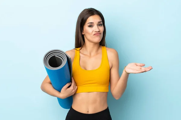 Mujer Deportiva Joven Con Estera Aislada Sobre Fondo Azul Haciendo —  Fotos de Stock