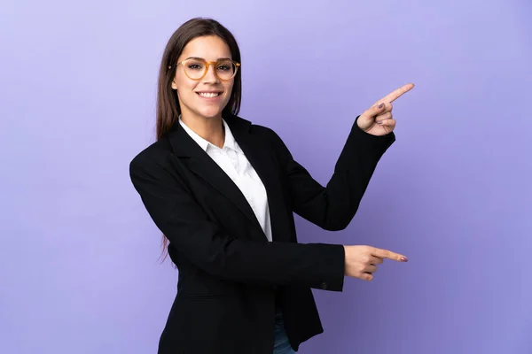 Business Woman Isolated Purple Background Pointing Finger Side Presenting Product — Zdjęcie stockowe