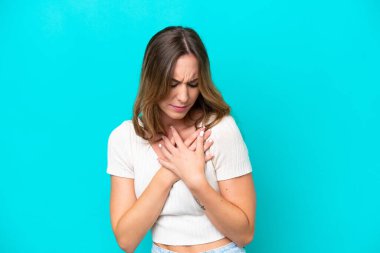 Mavi arka planda izole edilmiş beyaz bir kadın. Kalbinde ağrı var.