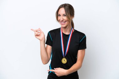 Beyaz arka planda izole edilmiş madalyalı beyaz bir kadın şaşırmış ve işaret ediyor.