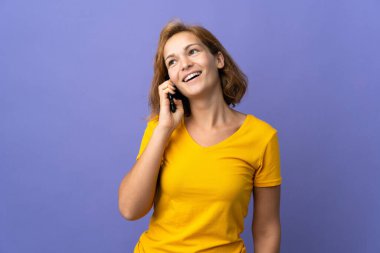 Mor arka planda izole edilmiş genç Gürcü kadın cep telefonuyla biriyle sohbet ediyor.