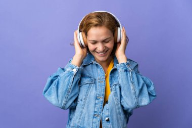 Mor arka planda müzik dinleyen genç Gürcü kadın.