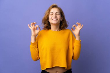 Genç Gürcü kadın mor arka planda Zen pozuyla izole edilmiş