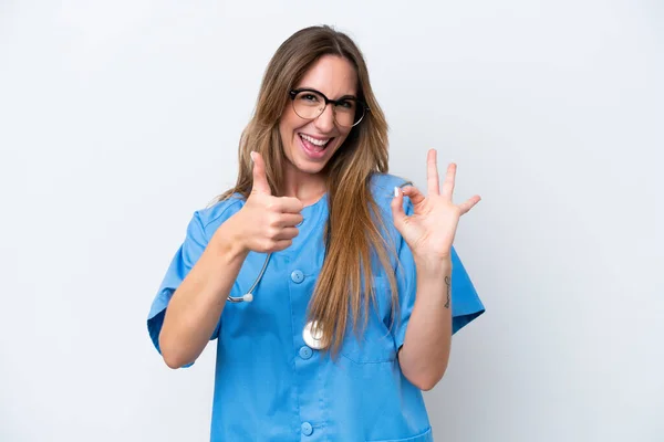 若いです外科医女性隔離上の青背景ショーOkサインと親指アップジェスチャー — ストック写真