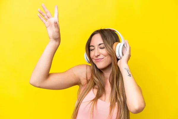 Joven Mujer Caucásica Aislada Sobre Fondo Amarillo Escuchando Música Bailando —  Fotos de Stock