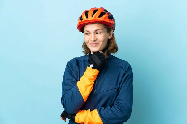 Νεαρή Ποδηλάτισσα Γυναίκα Απομονωμένη Μπλε Φόντο Κοιτάζοντας Στο Πλάι Και — Φωτογραφία Αρχείου