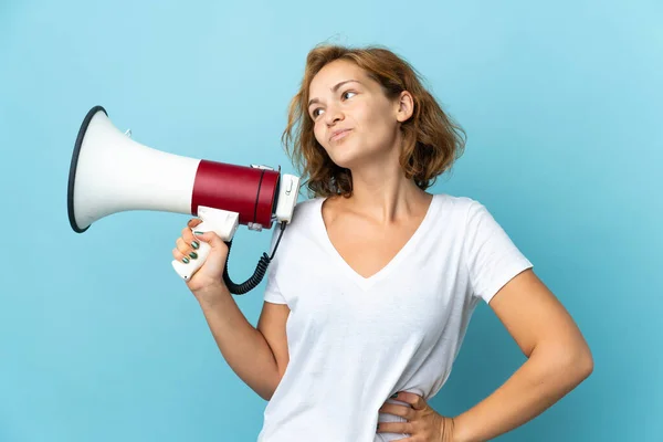 Jonge Georgische Vrouw Geïsoleerd Blauwe Achtergrond Met Een Megafoon Denken — Stockfoto