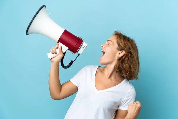 Jonge Georgische Vrouw Geïsoleerd Blauwe Achtergrond Schreeuwen Door Een Megafoon — Stockfoto