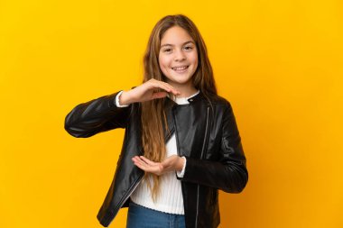 İzole edilmiş sarı arkaplan üzerinde çocuk bir reklam eklemek için avuç içinde hayali alan tutuyor