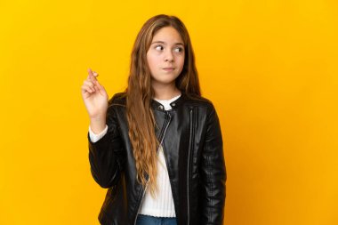 İzole edilmiş sarı arka planda, şans dileyen ve en iyisini dileyen çocuk.