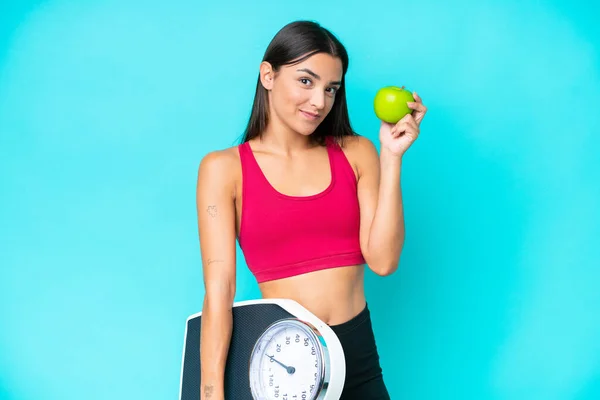 Young Caucasian Woman Isolated Blue Background Weighing Machine Apple — Stock Photo, Image