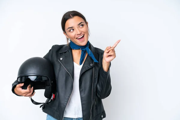 若いですCaucasian女性とともにオートバイヘルメット隔離上の青の背景に実現しようとして解決策指を持ち上げながら — ストック写真