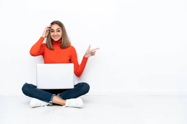 Genç Beyaz Bir Kadın Dizüstü Bilgisayarla Yerde Oturuyor Şaşırmış Işaret — Stok fotoğraf