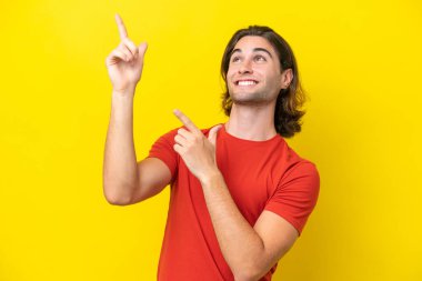 Sarı arka planda izole edilmiş beyaz, yakışıklı bir adam işaret parmağıyla işaret etmek harika bir fikir.