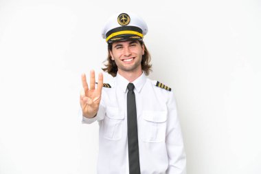 Yakışıklı uçak pilotu beyaz arka planda izole edilmiş mutlu ve parmaklarıyla üçe kadar sayıyor