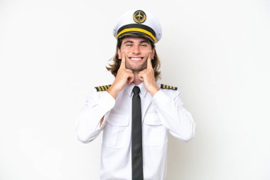 Yakışıklı uçak pilotu beyaz arka planda izole edilmiş mutlu ve hoş bir ifadeyle gülümsüyor.