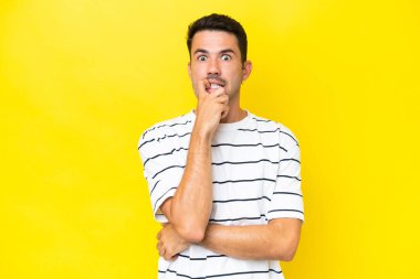 Genç, yakışıklı, soyutlanmış sarı arka plan gergin ve korkmuş.