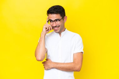 Genç yakışıklı adam, izole edilmiş sarı arka plan gülüyor.