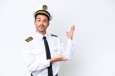 İzole edilmiş beyaz arka plan üzerinde uçak pilotu davet edilmek için ellerini yana uzatıyor.