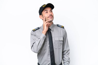 İzole edilmiş beyaz arka planda genç bir güvenlik görevlisi yukarı bakarken bir fikir düşünüyor.