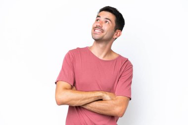 Genç yakışıklı, soyutlanmış beyaz bir arka plan. Gülümserken yukarı bakıyor.