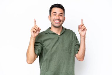 Soyutlanmış beyaz arka planı olan yakışıklı genç adam harika bir fikre işaret ediyor.