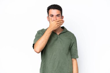 İzole edilmiş beyaz arka planda genç yakışıklı bir adam. Ağzını eliyle kapatıyor.