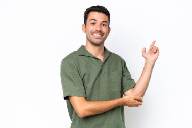 Genç yakışıklı, soyutlanmış beyaz arka plan mutlu ve yukarıya bakıyor.