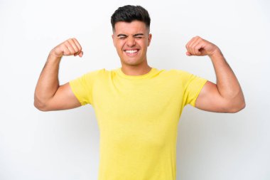 Beyaz arka planda izole edilmiş beyaz, yakışıklı genç bir adam güçlü bir jest yapıyor.