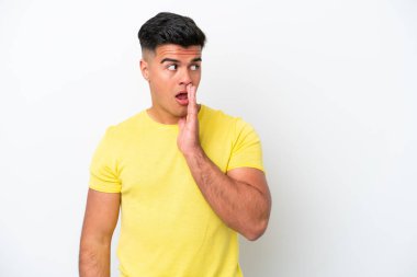 Beyaz arka planda izole edilmiş beyaz tenli yakışıklı bir adam yan tarafa bakarken sürpriz bir jest yapıyor.