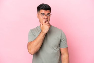 Beyaz tenli yakışıklı bir adam pembe arka planda izole edilmiş gergin ve korkmuş.