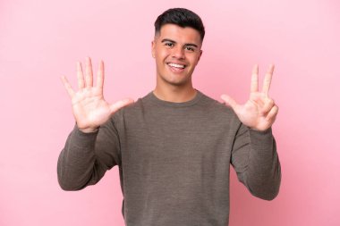 Pembe arka planda izole edilmiş beyaz tenli yakışıklı sekiz parmaklı adam.