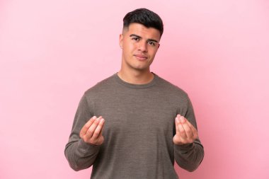 Beyaz tenli yakışıklı adam pembe arka planda izole edilmiş para hareketi yapıyor ama mahvolmuş.