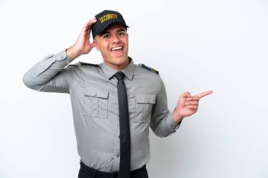 Beyaz arka planda izole edilmiş beyaz tenli genç bir güvenlik görevlisi şaşırmış ve parmağıyla kenarı işaret ediyor.