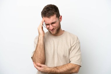 Beyaz arka planda başı ağrıyan genç beyaz bir adam.