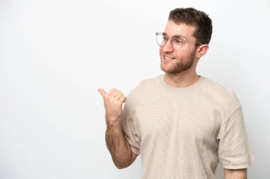 Beyaz arka planda izole edilmiş genç beyaz bir adam bir ürün sunmak için kenarı işaret ediyor.