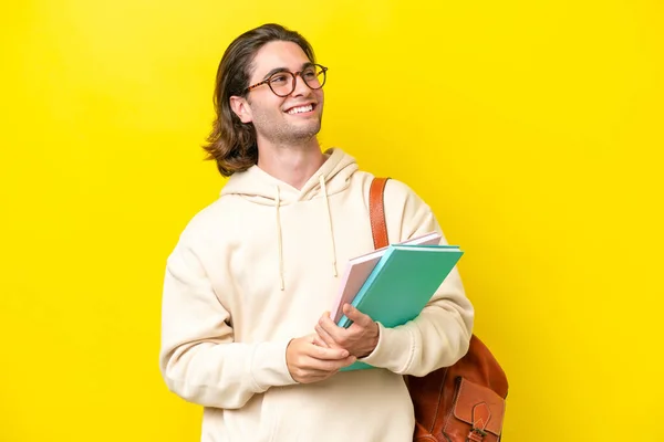 Young Student Handsome Man Isolated Yellow Background Looking Side Smiling — 스톡 사진